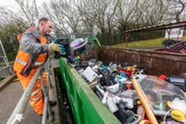 Man putting waste into a container at a recycling centre