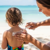 Child having sun cream applied