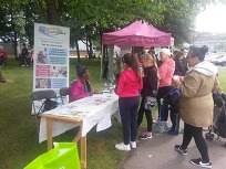 Photo of a stall and visitors at a carers' roadshow