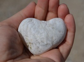 White heart shaped stone on a child's hand