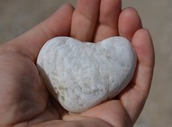 White heart shaped stone on a child's hand