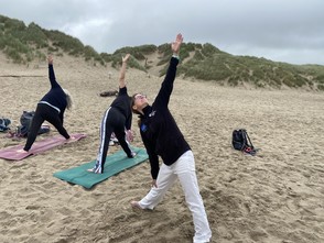 Yoga on the beach at Morfa Harlech with the dunes in the background.