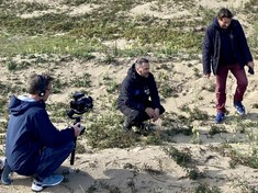 Three people in the sand dunes at Morfa Harlech being filmed for ITV Coast and Country