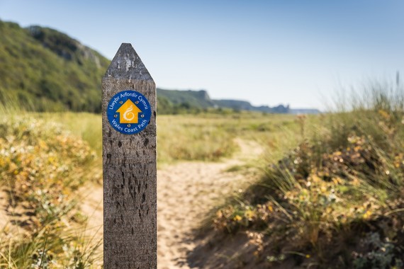 A way-marker with the Wales Coast Path logo