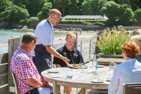 waitor serving food to customers at the table 