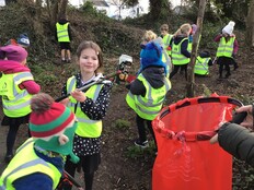 Learners gather litter from a woodland area with litter pickers