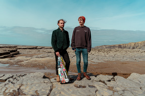 two men standing on a beach