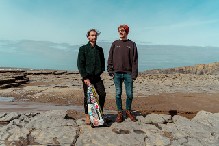 two men standing on a beach