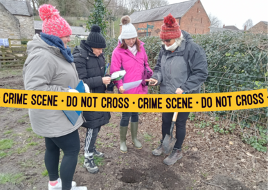 Teachers gather to dig a soil pit to take a soil sample