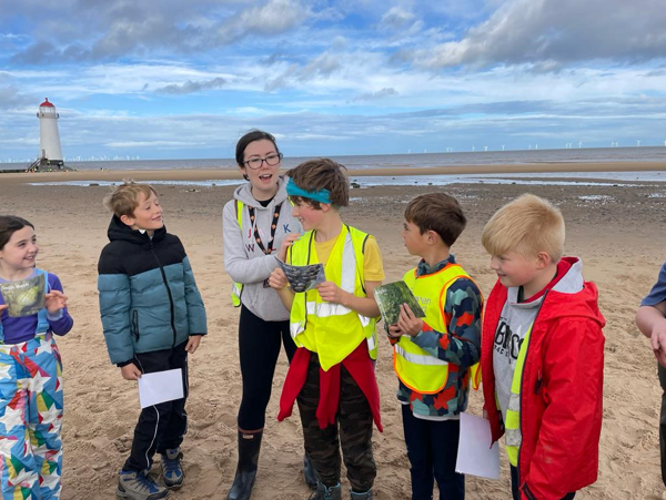 Pupils and teacher discuss food chains on the beach