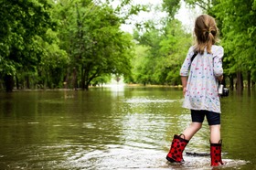 Girl walks in wellies through floods