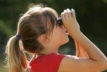 Girl looks up through binoculars