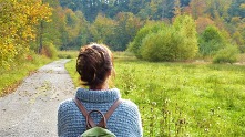 Woman looks out on view of woodland