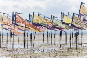 Art flags standing upright on a beach