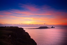 Sunset bright orange and blue Worms Head todal island