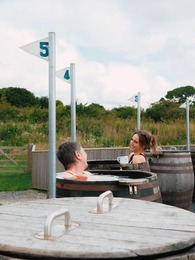 two women sitting in seaweed barrels