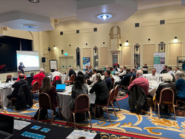 People sat around tables at a network event