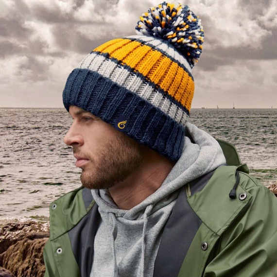 man wearing a wooly stripy hat with a pom pom on top