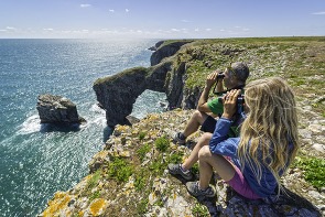 couple birdwatching on the coast