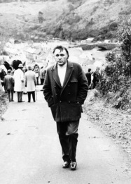 man walking up a street on a film set Richard Burton