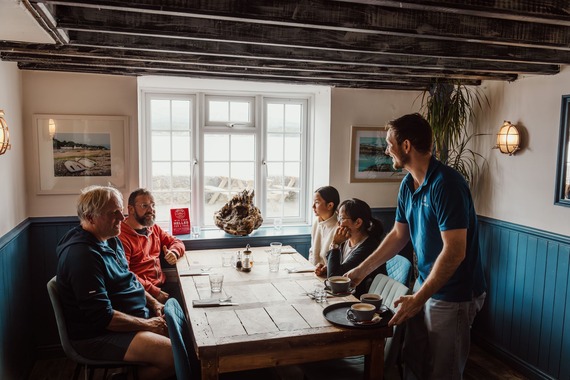 group of people being served drinks in a pub