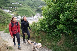 2 women walking a dog on a lead