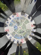 people's feet around a mural artwork on the floor 