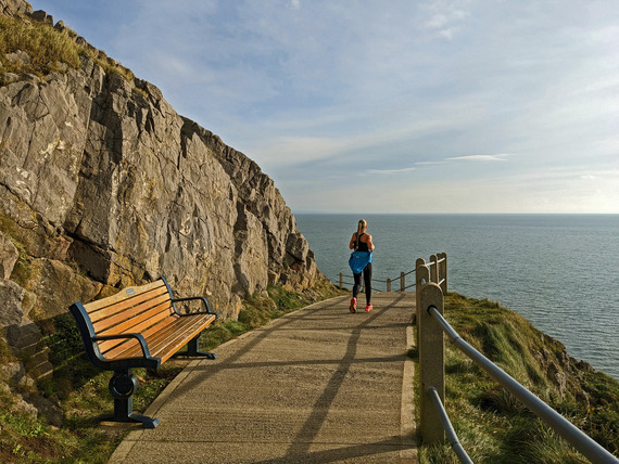 person on a wide footpath on the coast