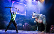 Dinosaur on stage roaring at actor