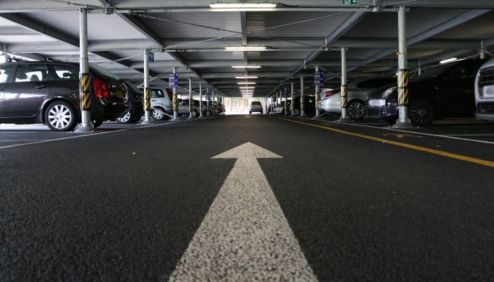 Image of the interior of a car park with an arrow on the ground pointing forward. 
