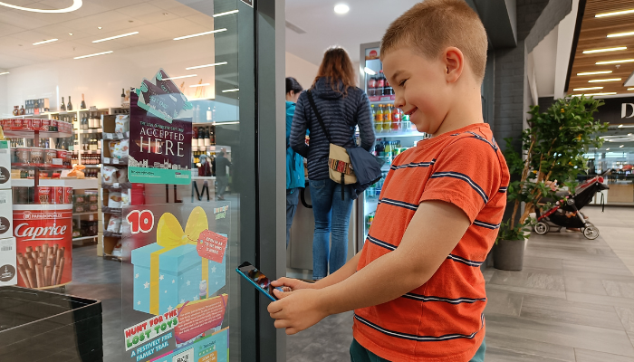 Child looking at Imp decal as part of 'hunt for the lost toys' trail