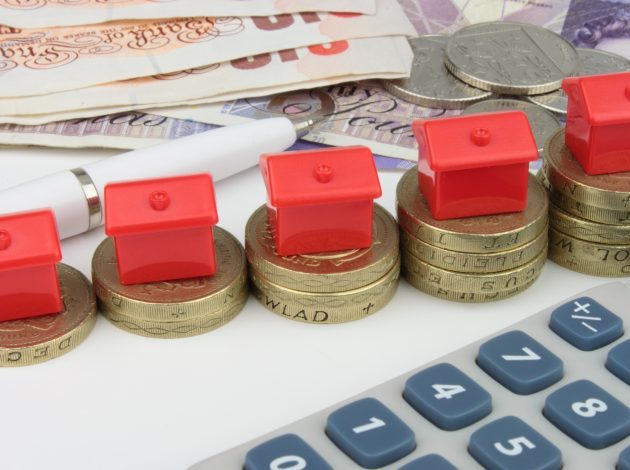 Rows of pound coins with monopoly houses on them