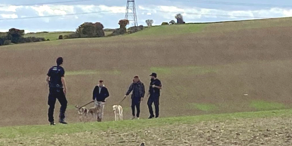 Rural engagement officers approach hare coursing suspects in a field