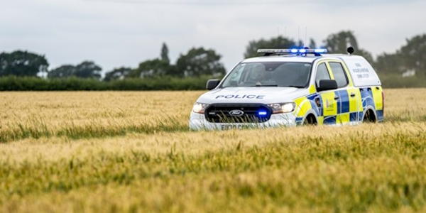A four by four police vehicle in a field of crops