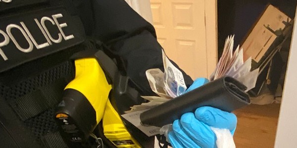 Officer holding cash and drugs