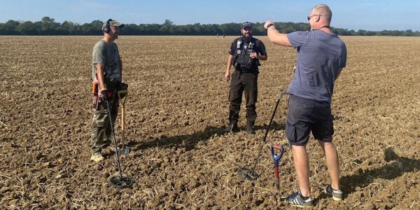 Officer talks with members of Braintree Metal Detecting Club at an organised dig in the district near Cressing