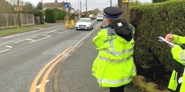 Community Speed Watch volunteers in fluorescent jackets by a roadside in Colchester