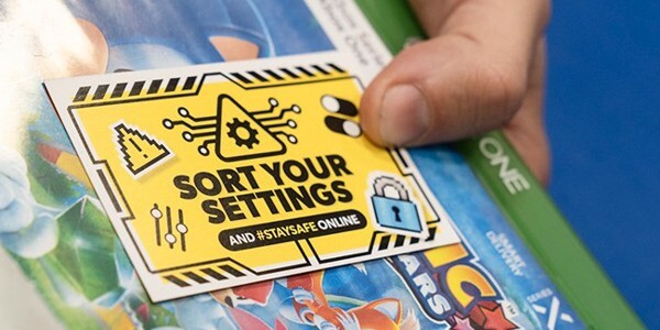 Sort your settings label on a video game box held by a hand in store