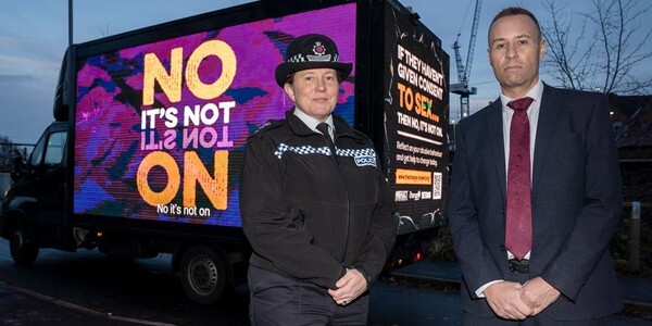 Ch/Supt Claire Talbot and D/Supt Neil Pudney in front of a van displaying digital sign saying 'No it's not On'