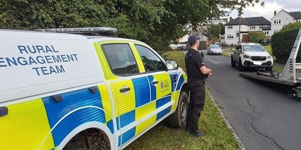 Rural Engagement Team officer supervises while a car is loaded onto a transporter