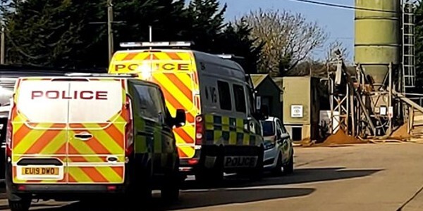 Police vehicles outside near the industrial area