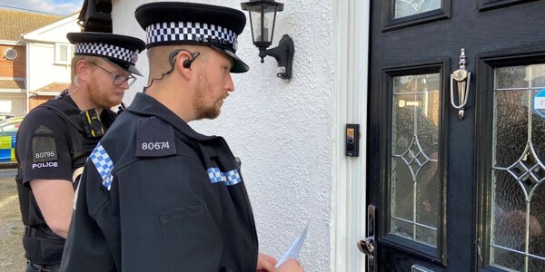 Two officers outside a front door