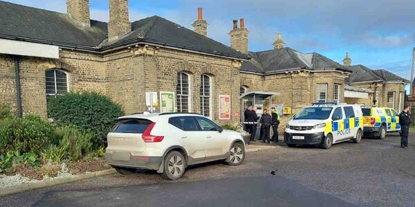 Officers and police car outside a house in a residential street