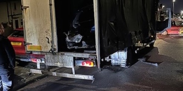 Heavy goods vehicle at night with rear door open revealing cloned car
