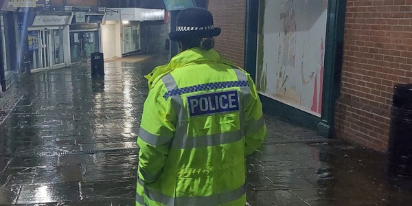 Officer on patrol in the rain at night
