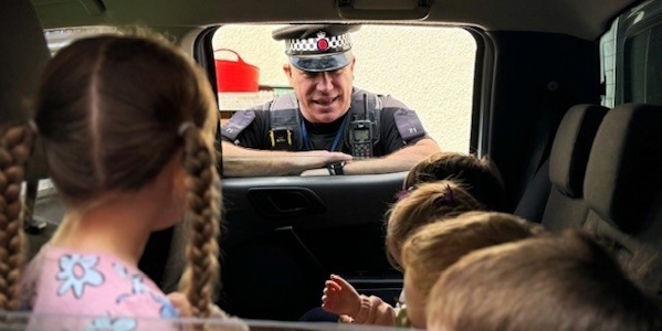 officer talking to children at a nursery.