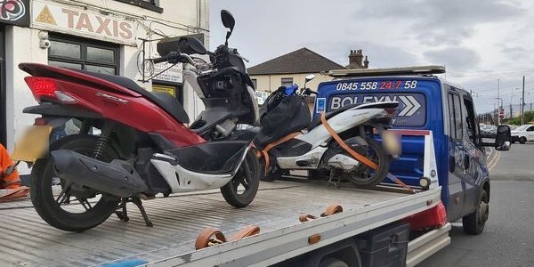 Red scooter on a transporter lorry