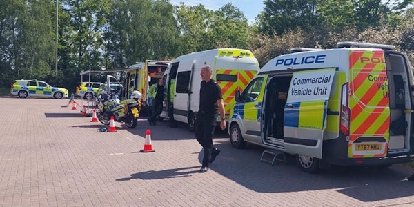 Police vehicles and officers assembled at the start of the operation
