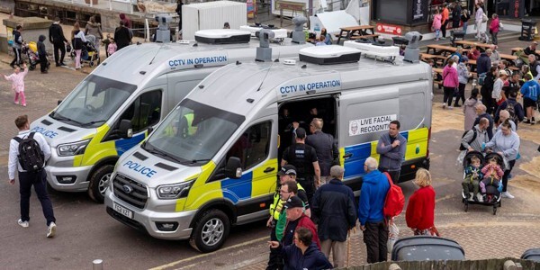 Two specialist Live Facial Recognition police vans in Clacton surrounded by people