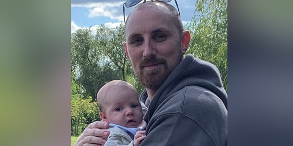 Mitchell Walker holding his baby son